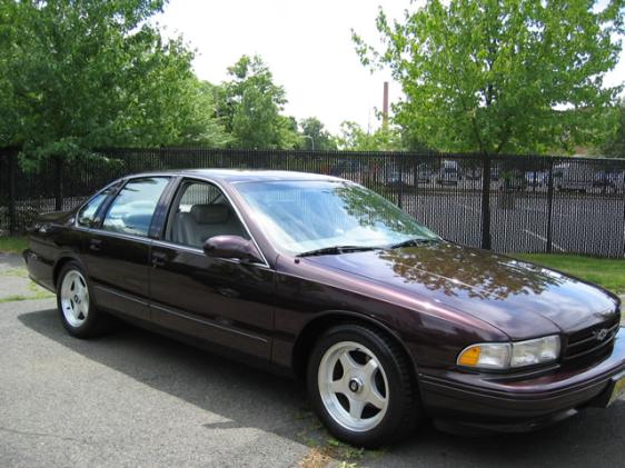 1994 Chevrolet Impala SS, dark purple, parked on asphalt with trees and fence in background