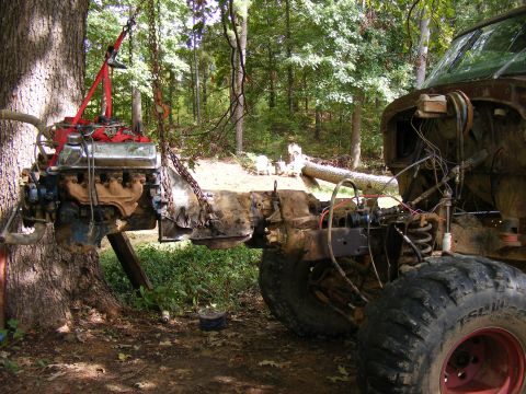1978 Ford Bronco - The engine and transmission are being removed from a vehicle in an outdoor setting.