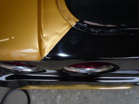 1970 Chevrolet Camaro - Close-up of the rear quarter panel and taillights on a gold and black 1970 Chevrolet Camaro.