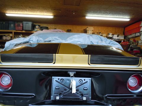 1970 Chevrolet Camaro - Rear view of a 1970 Chevrolet Camaro with distinctive gold and black racing stripes.