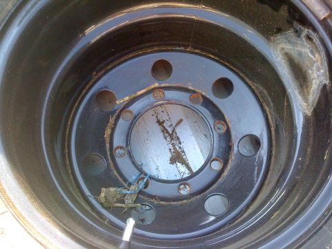 1987 Suzuki Samurai - Close-up of a vehicle's wheel, showing its construction and some accumulated dirt.
