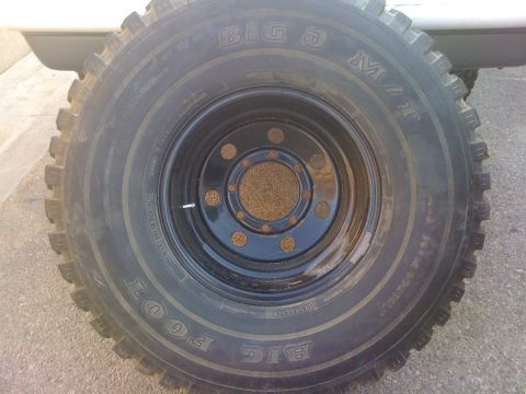 1987 Suzuki Samurai - This image shows a close-up of a large tire and wheel, identified as "BIGFOOT" M/T.