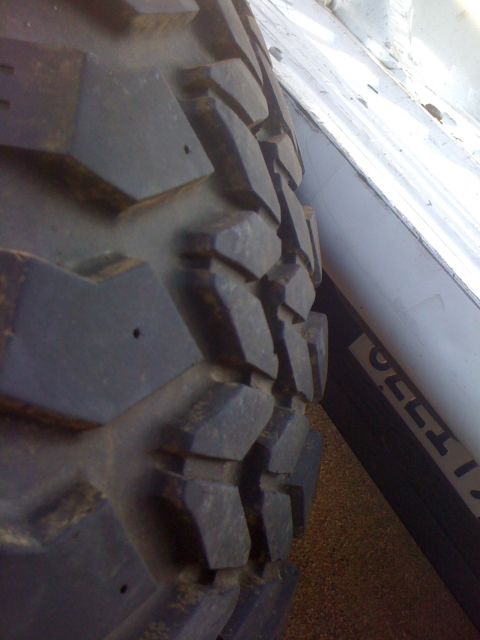 1987 Suzuki Samurai - Aggressive tread pattern on an off-road tire is visible.