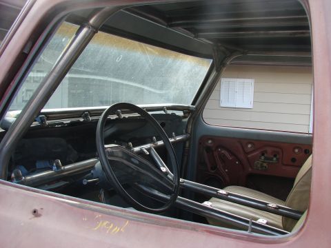 1979 Ford Bronco - The interior of a vehicle shows extensive roll cage modifications and exposed interior panels.