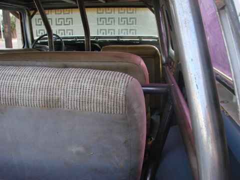 1979 Ford Bronco - The interior of a vehicle shows patterned seats and a roll cage, with a steering wheel visible.