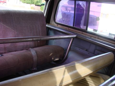 1979 Ford Bronco - Interior view of a vehicle with a roll cage and seats, showing a seatbelt.
