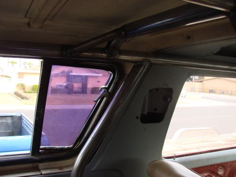 1979 Ford Bronco - Custom roll cage installed inside a vehicle, with a view of the exterior through the window.