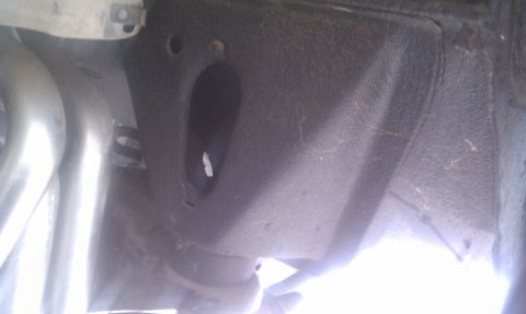 1979 Ford Bronco - This image shows a close-up view of a vehicle's parking brake assembly and part of the exhaust system.