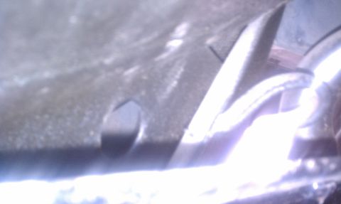 1979 Ford Bronco - Underside view of a vehicle's parking brake mechanism, showing metal parts and a cable.