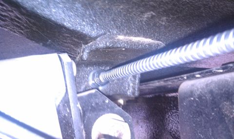 1979 Ford Bronco - A coiled parking brake cable is visible, attached to a metal bracket, with a SuperMotors logo in the corner.