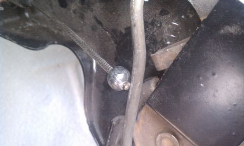1979 Ford Bronco - Detail of the parking brake cable mechanism, showing the cable and its attachment point.