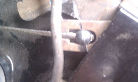 1979 Ford Bronco - This image shows a close-up view of a parking brake cable and its attachment point to a lever.