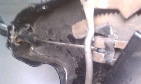 1979 Ford Bronco - Detail of a vehicle's parking brake mechanism, showing the cable and ratchet system.