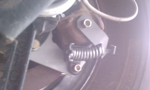 1979 Ford Bronco - The parking brake assembly, a coiled spring and metal bracket, is visible near the wheel.