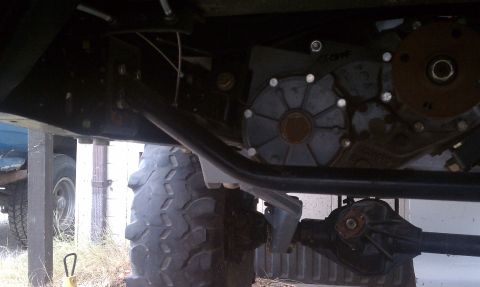1979 Ford Bronco - The underside of a vehicle shows mechanical components including a transfer case and differential.