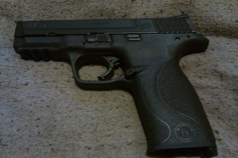 2000 Mercury Grand Marquis - A black semi-automatic pistol with textured grip is shown against a neutral background.