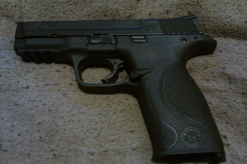Black semi-automatic pistol on a textured surface. Text on slide reads 'M&P .40'