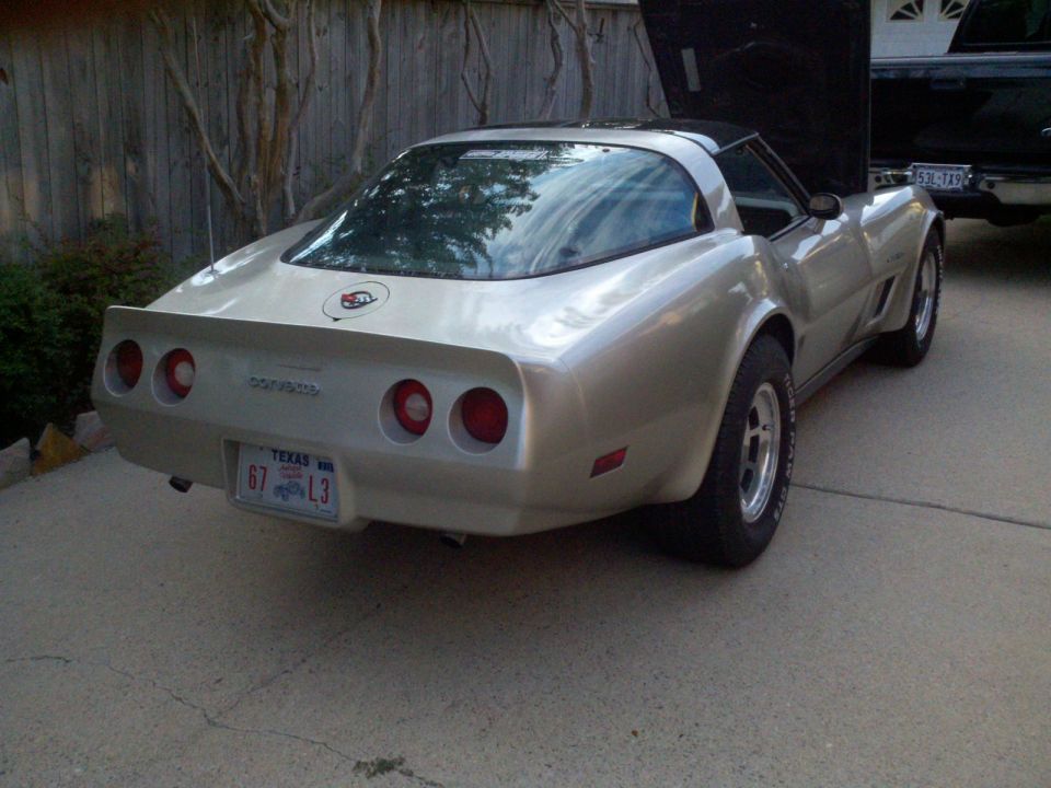 Rear view of a silver 1982 Chevrolet Corvette with its hood open