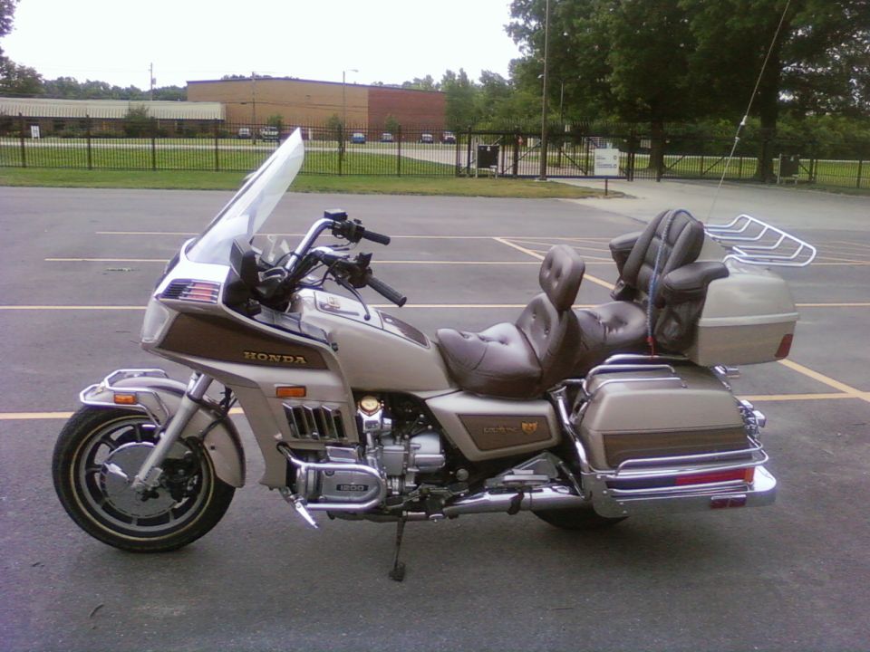Tan and brown Honda Gold Wing motorcycle parked on asphalt