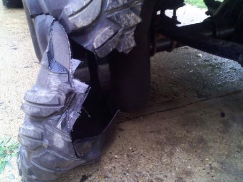 1997 Ford Ranger - A close-up view of a severely damaged tire, revealing its internal structure and the vehicle's suspension components.