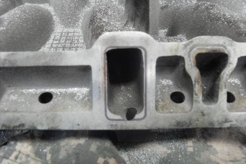 1997 Ford Ranger - Close-up of an aluminum intake manifold with machined ports, showing signs of wear and debris.
