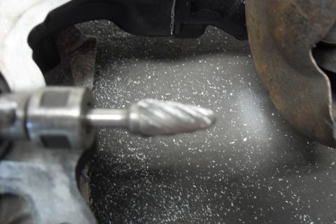 1997 Ford Ranger - A close-up view of a rotary burr tool in action, grinding metal and creating debris.