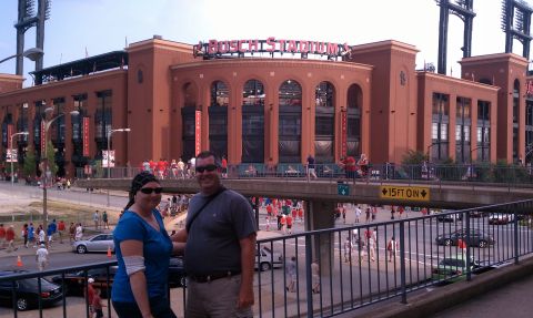 1979 Ford Bronco - A couple stands on a walkway with Busch Stadium visible behind them, with many people milling about.