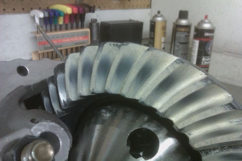 1999 Chevrolet Camaro - Close-up of a differential ring gear showing tooth contact patterns, with tools and spray cans visible.