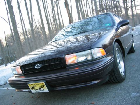 1996 Ford Crown Victoria - This dark sedan features a prominent Chevrolet grille and is seen from the front with a New Jersey license plate.