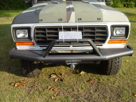 1979 Ford Bronco - The front of a 1979 Ford Bronco is shown, a camouflage pattern on the hood and a heavy-duty bumper.