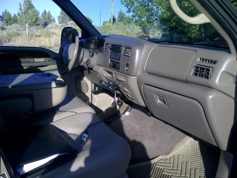 2004 Ford F-250 - The interior of a 2004 Ford F-250 pickup truck is shown from the passenger side, with a view of the dashboard and seats.