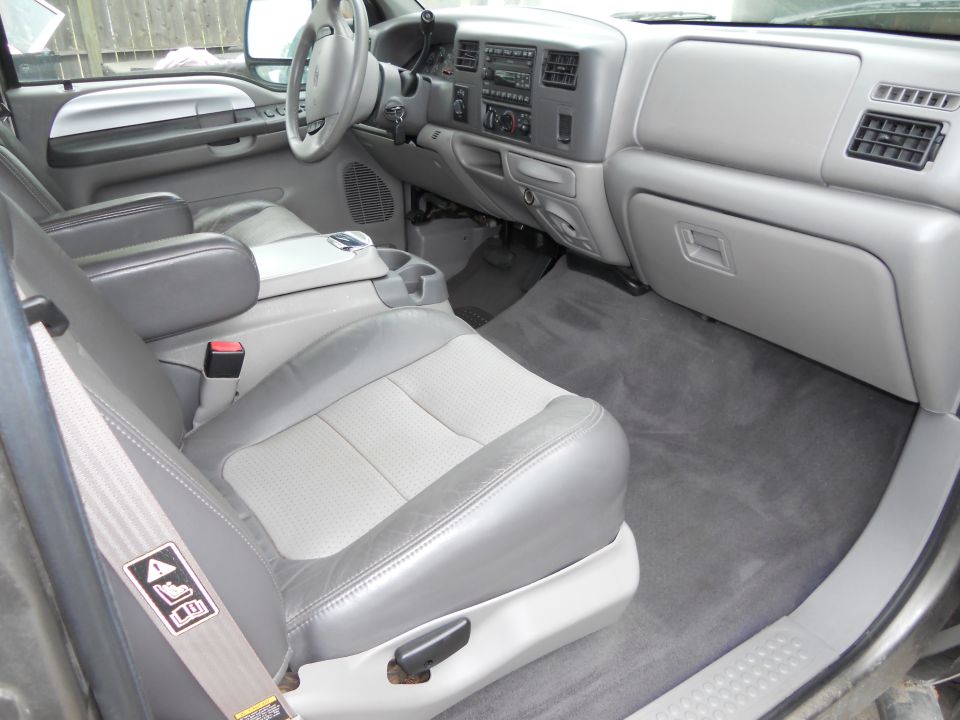 Gray Ford Super Duty interior from passenger door: leather bucket seat, console and dash