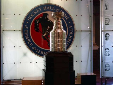 1999 Ford Crown Victoria - The Stanley Cup is displayed at the Hockey Hall of Fame, portraits of inductees on the wall.
