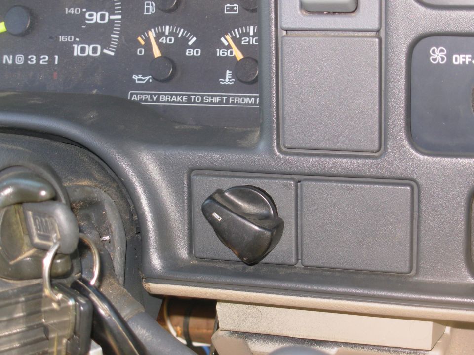 Black rotary knob on a gray dashboard below the gauge cluster