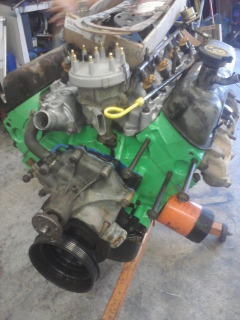 1989 Ford Bronco - This V8 engine assembly is mounted on an orange stand, showing its green-painted block and various components.