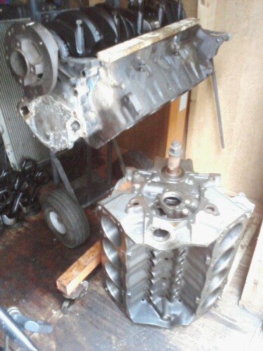 1989 Ford Bronco - Two engine blocks are visible in the image, one on a cart and another disassembled.