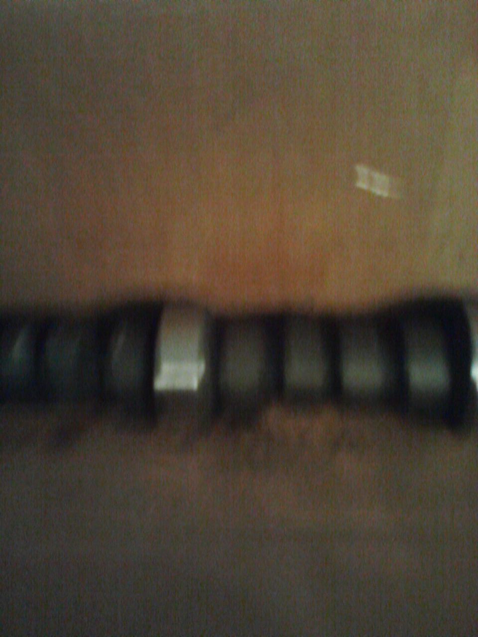 Camshaft with multiple lobes, some with reflective surfaces