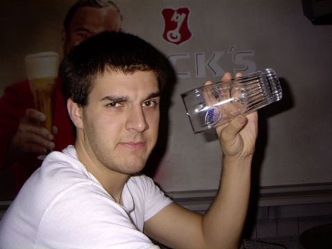 1999 Ford Crown Victoria - Man holding a beer glass in front of a poster of a man with a beer.
