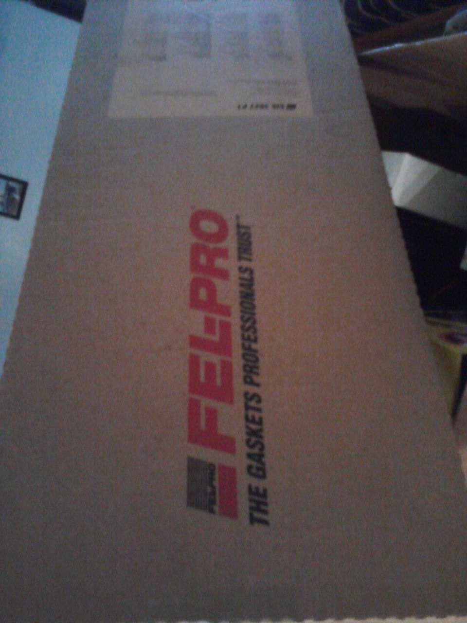Cardboard box with FEL-PRO logo and "THE GASKETS PROFESSIONALS TRUST" text
