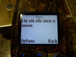 1999 Ford Crown Victoria - A cell phone displays a text message with options to navigate.