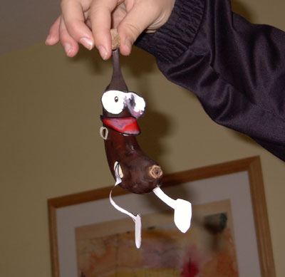 1999 Ford Crown Victoria - A whimsical, handmade banana doll with a cartoonish face is held up by a person's hand.