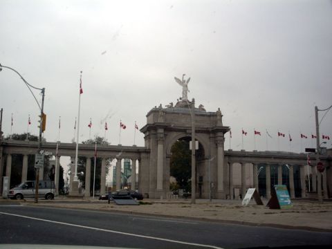 1999 Ford Crown Victoria - A monument with Canadian flags flying under a cloudy sky, with two vehicles visible.