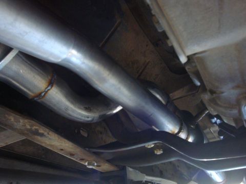1989 Ford Bronco - Close-up view of a vehicle's exhaust system, highlighting the pipes and frame structure.