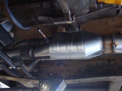 1989 Ford Bronco - The catalytic converter and exhaust pipes are visible from underneath the vehicle.