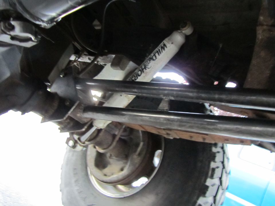 Undercarriage view of a white shock absorber with 'WILD HORSES' text