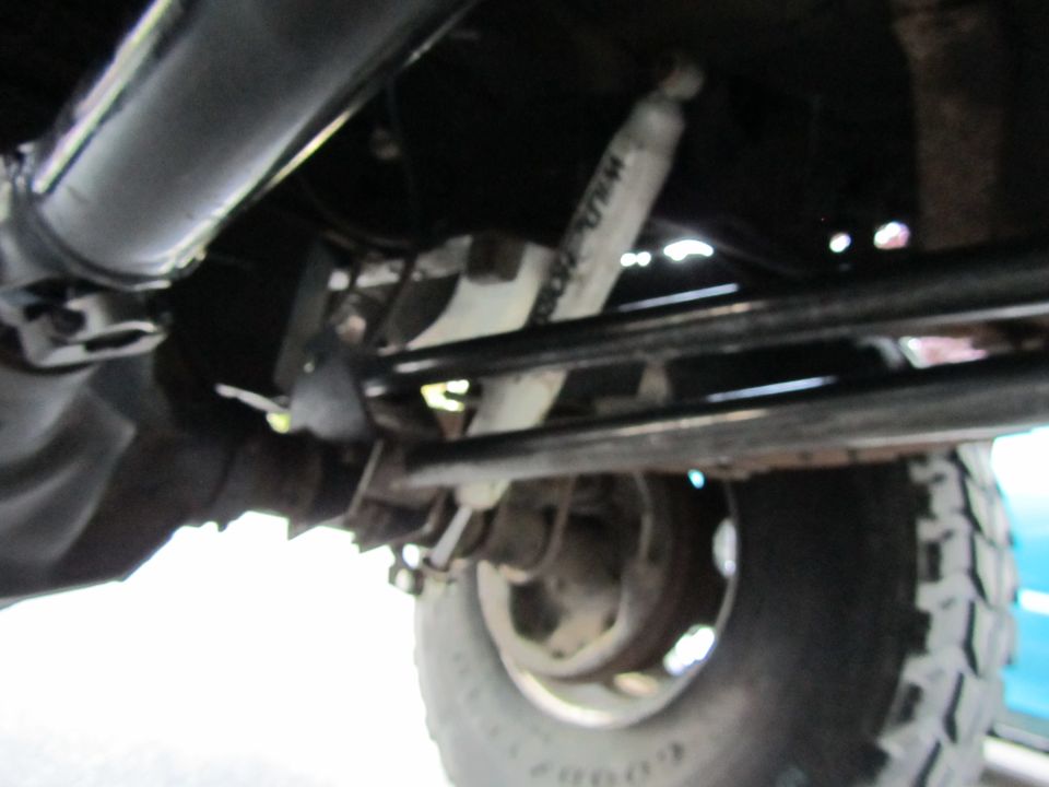 Undercarriage view showing suspension, shock absorber, and tire tread