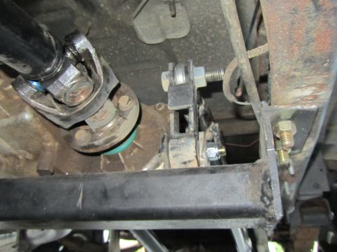 1984 Ford Bronco - Close-up view of the driveshaft and a modified transmission mount on a vehicle's underbody.