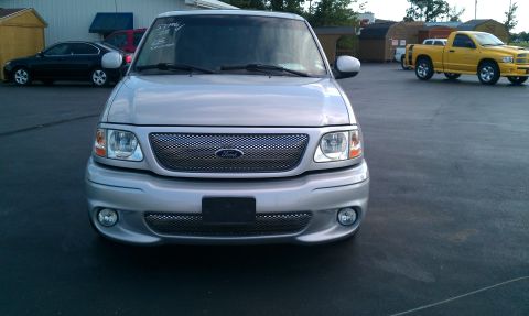 2002 Ford F-150 - A silver 2002 Ford F-150 truck is parked in an outdoor lot with other vehicles visible.