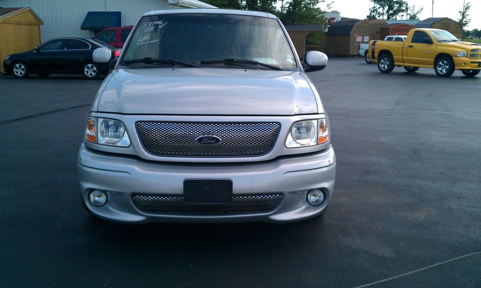 Silver 2002 Ford F-150 truck, front view, with chrome grille and fog lights