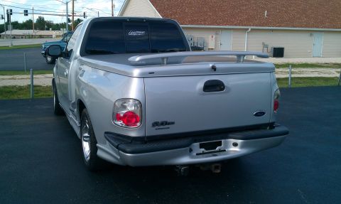2002 Ford F-150 - Rear view of a silver 2002 Ford F-150 pickup truck equipped with a tonneau cover and spoiler.